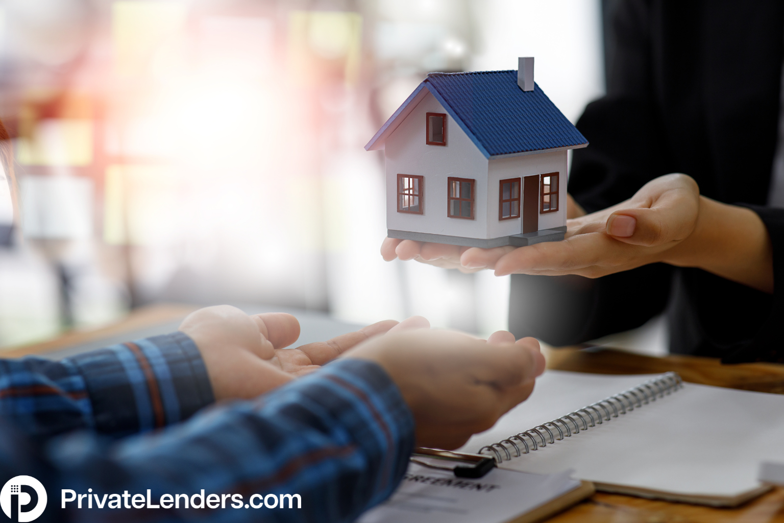 Picture of a woman putting a house into a mans hands symbolizing real estate investments